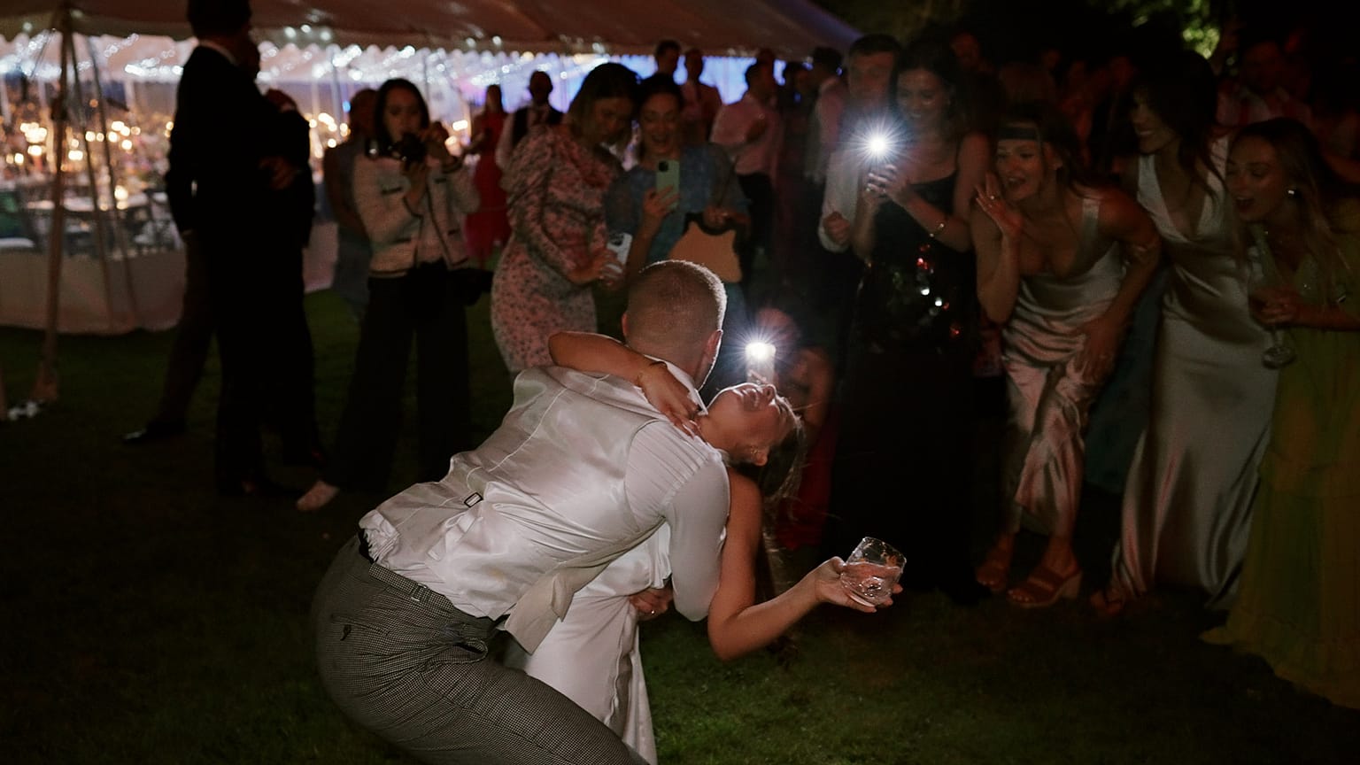 Wedding couple dancing surrounded by cheering guests.