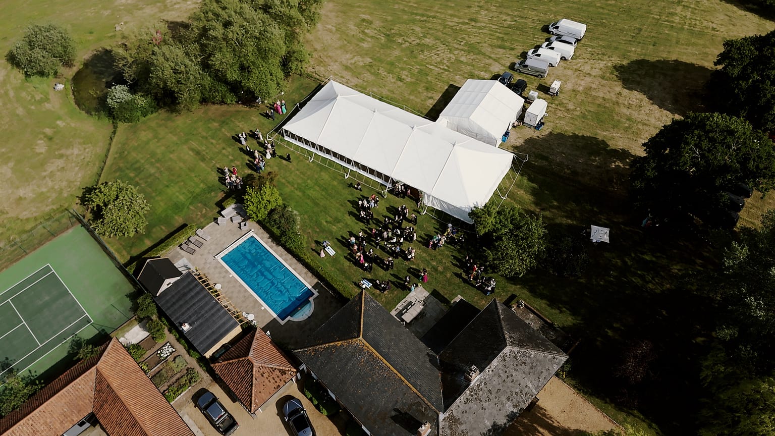 Aerial view of garden party with marquee and pool.