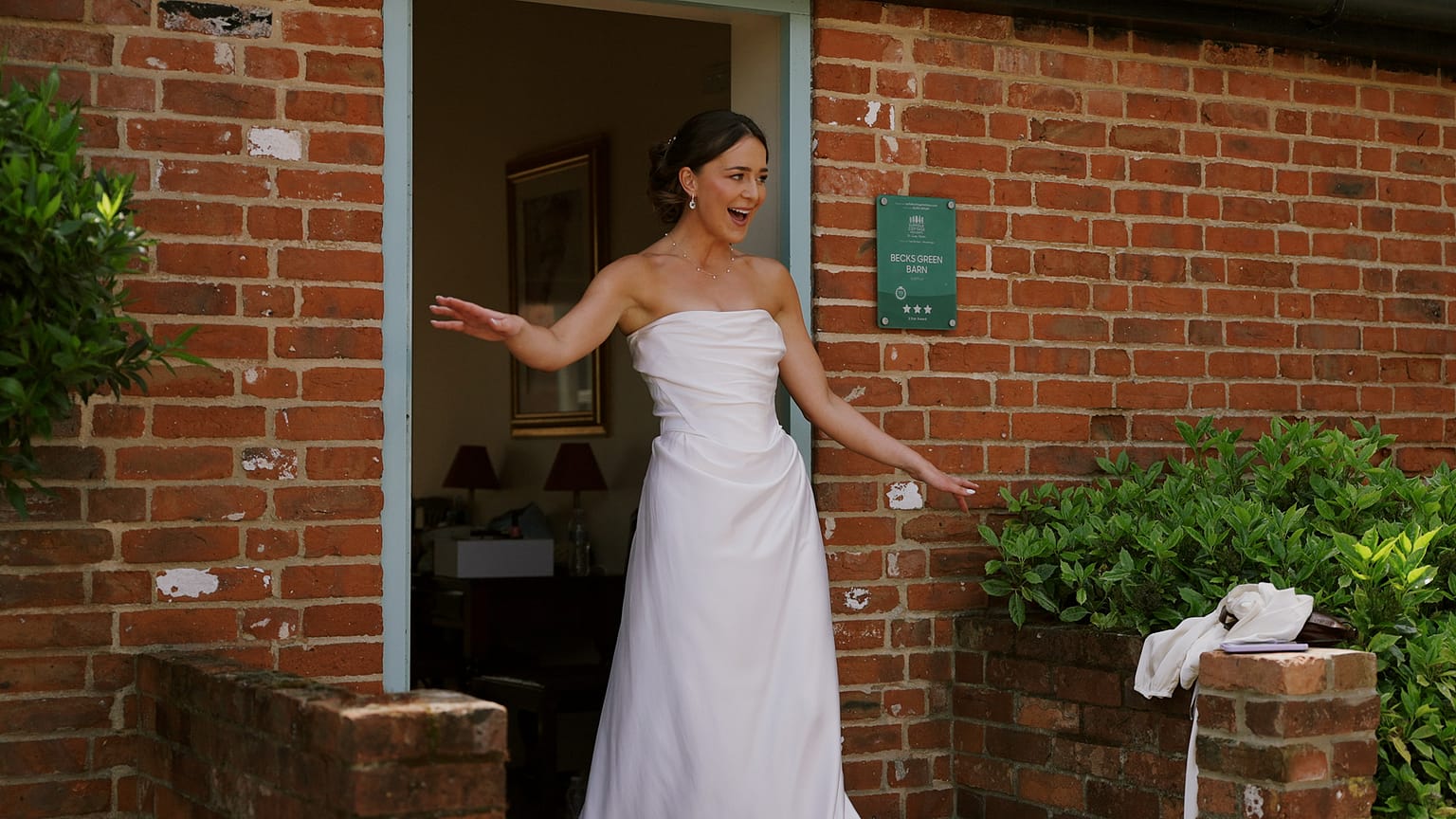 Bride in white dress smiling at rustic venue