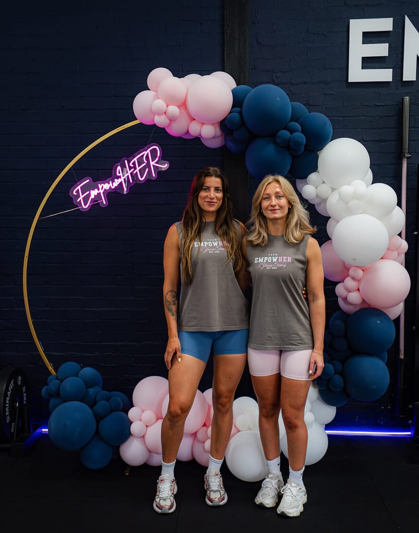 Two women posing at EmpowerHER fitness event