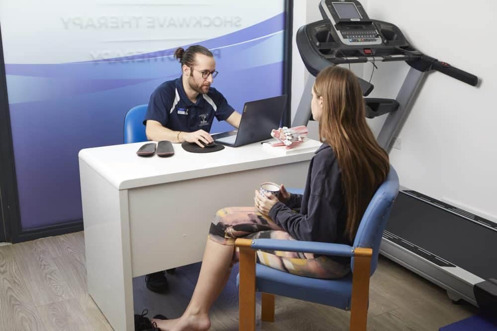 podiatrist looking at screen with patient