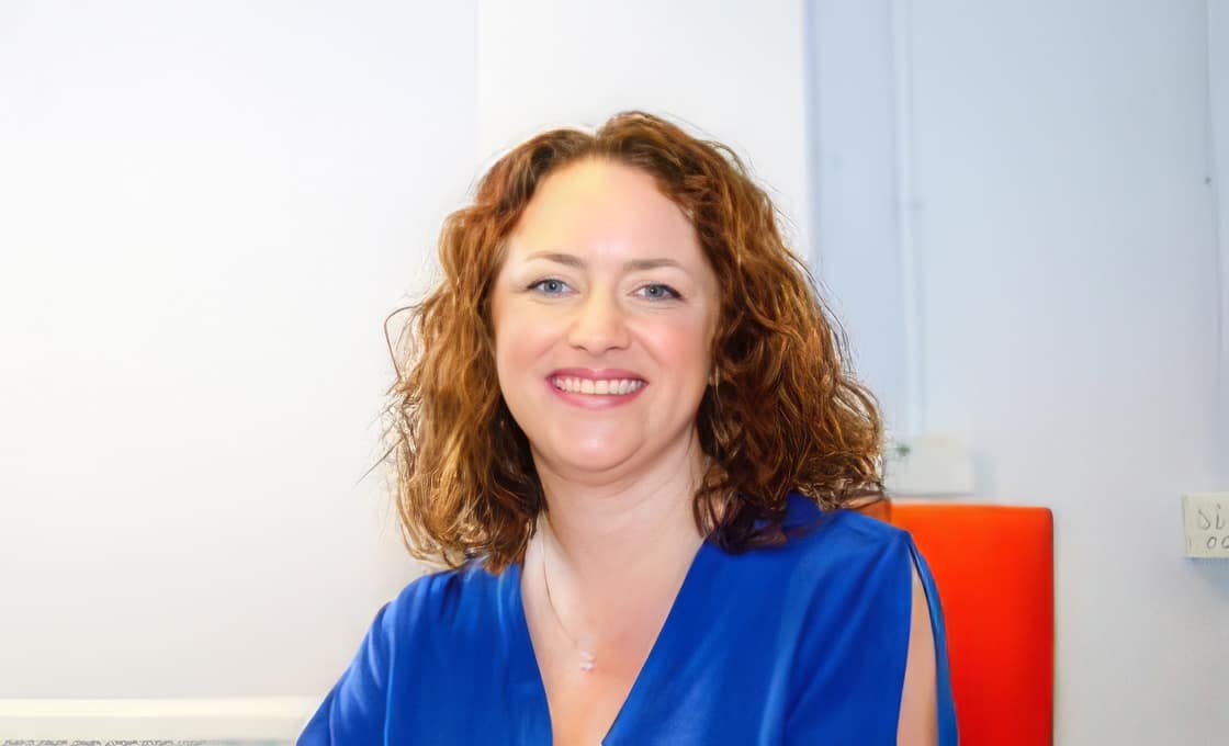 Smiling woman in blue blouse indoors