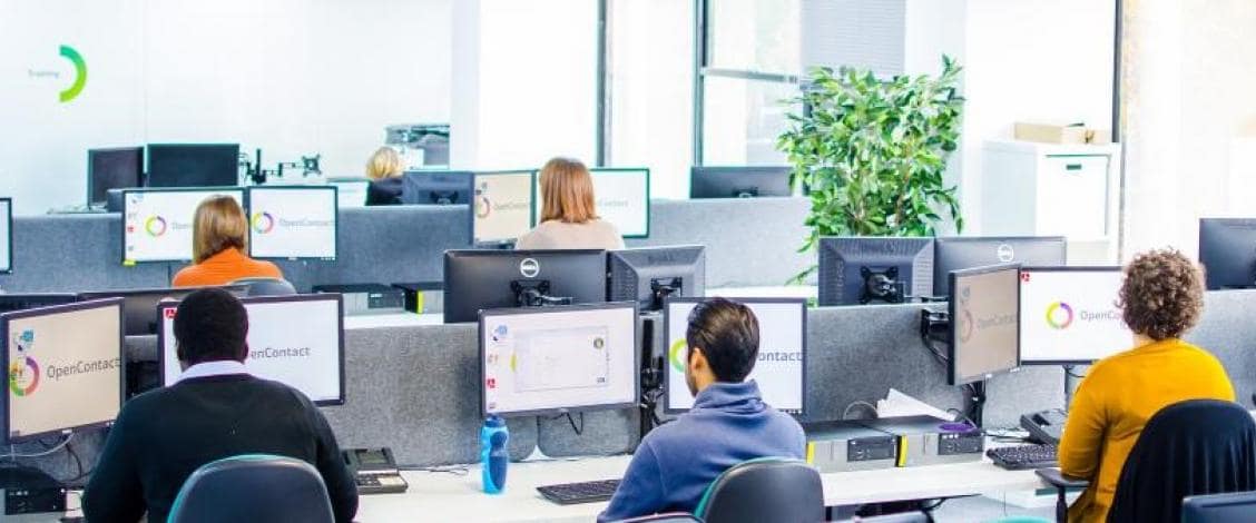 Employees working at computers in modern office