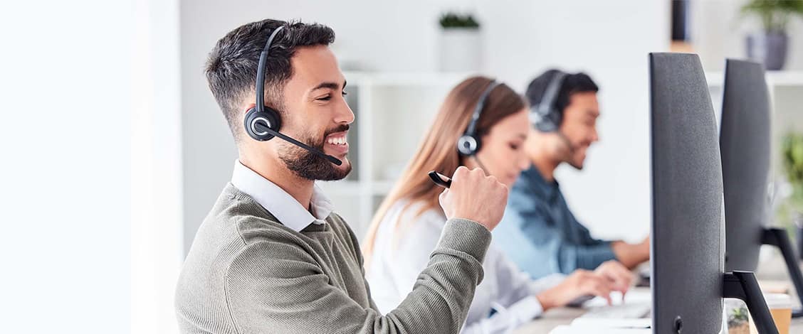 Smiling customer service agents working at computers