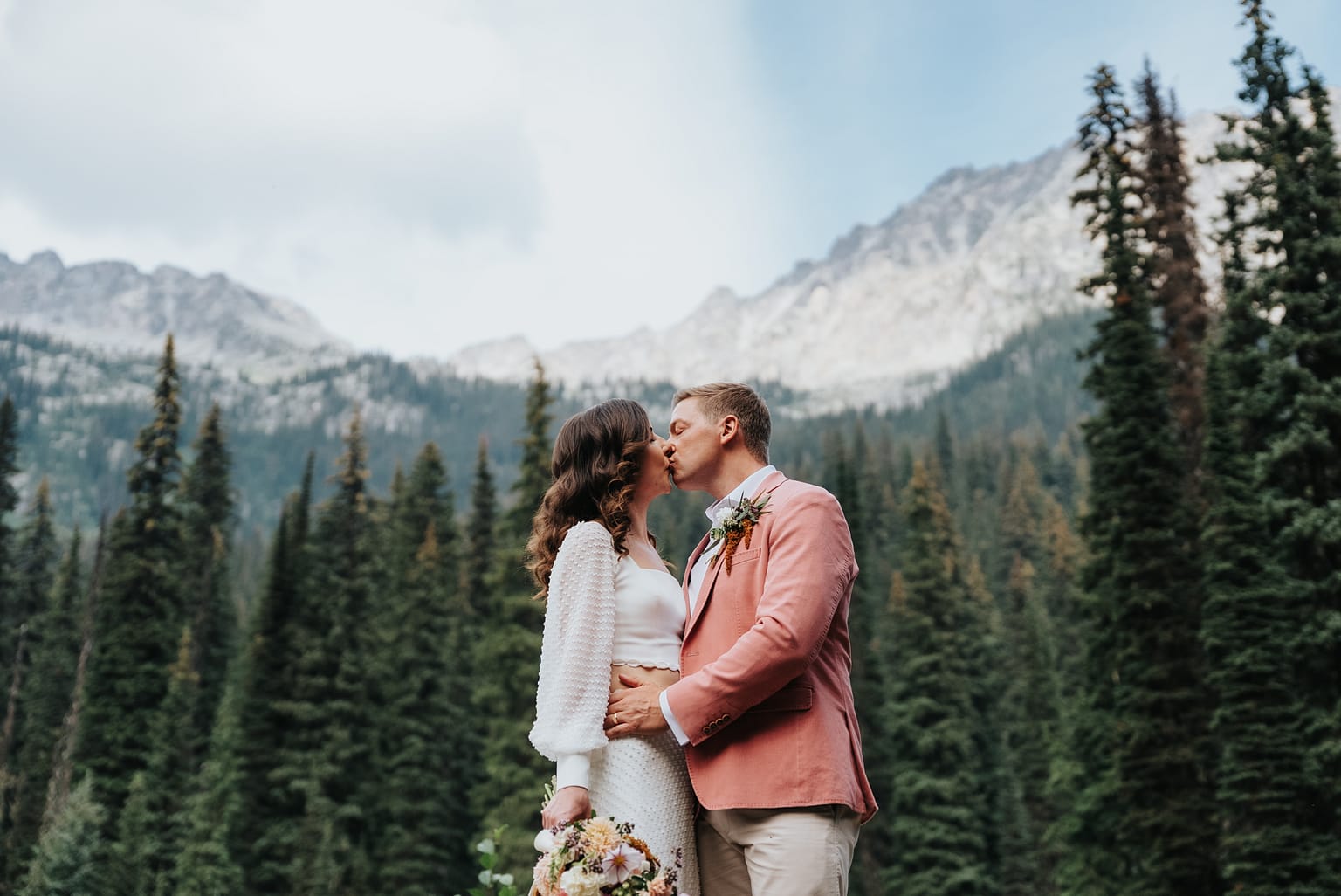 Couple kissing in mountain forest wedding scene, Lake Gibson
