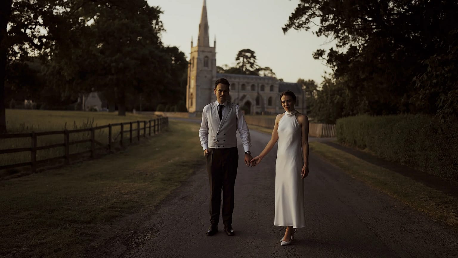 Couple holding hands near an old church.