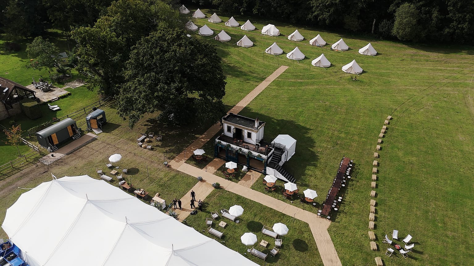 Aerial view of tents and event setup in field.