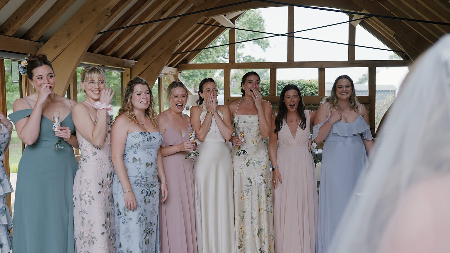 Bridesmaids reacting excitedly at wedding venue.