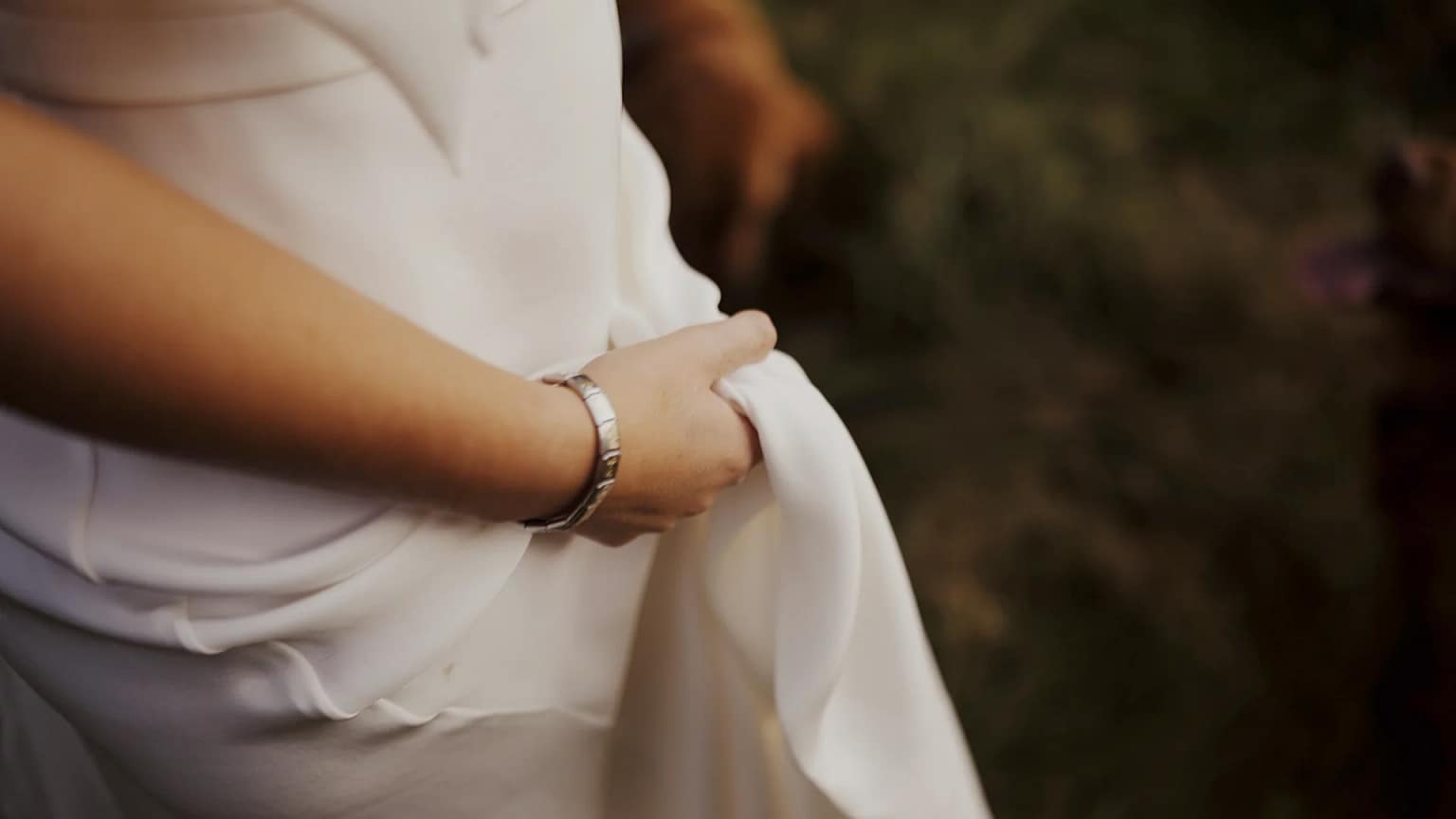 Person holding white fabric outdoors