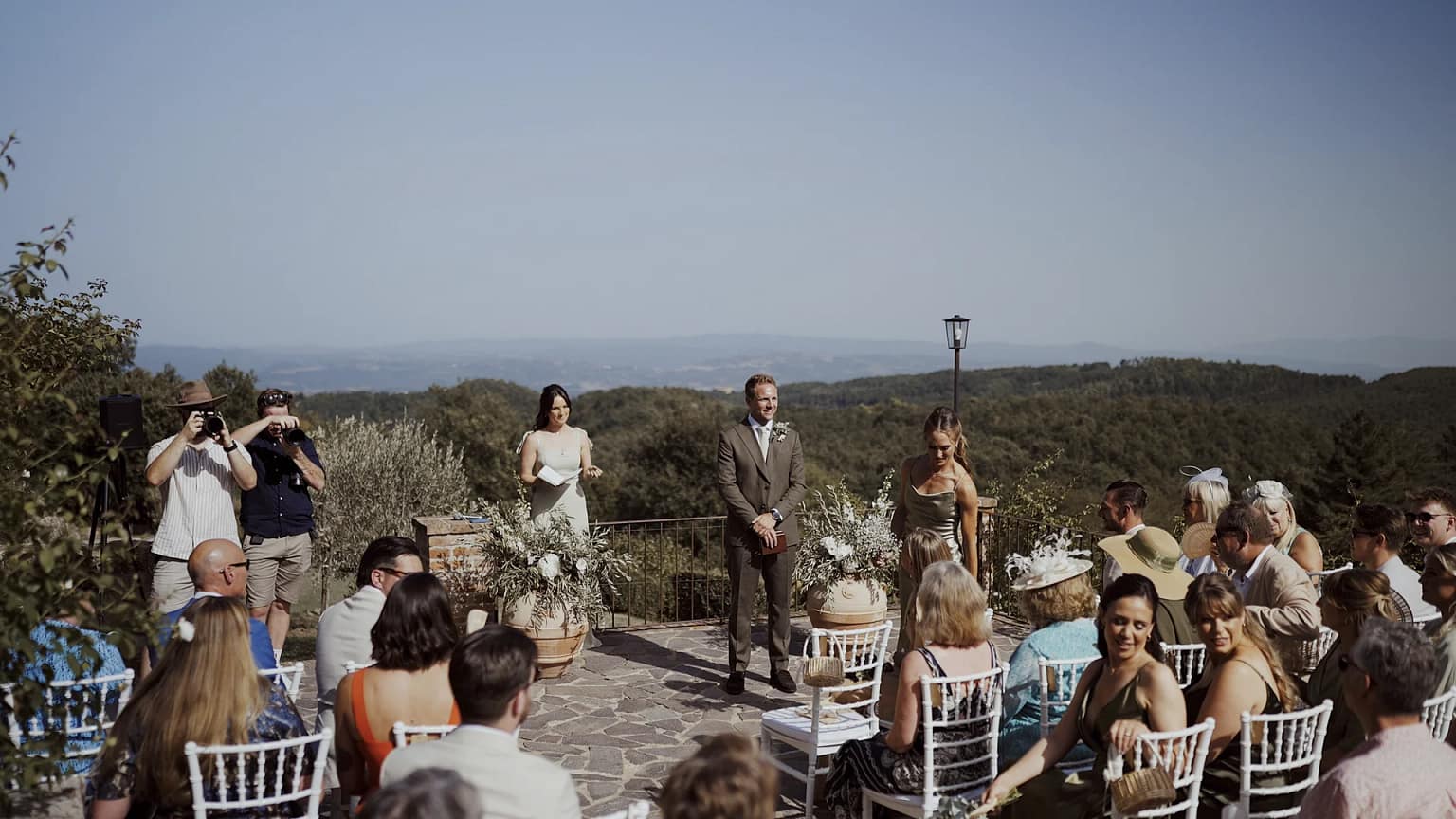 Outdoor wedding ceremony with guests seated.