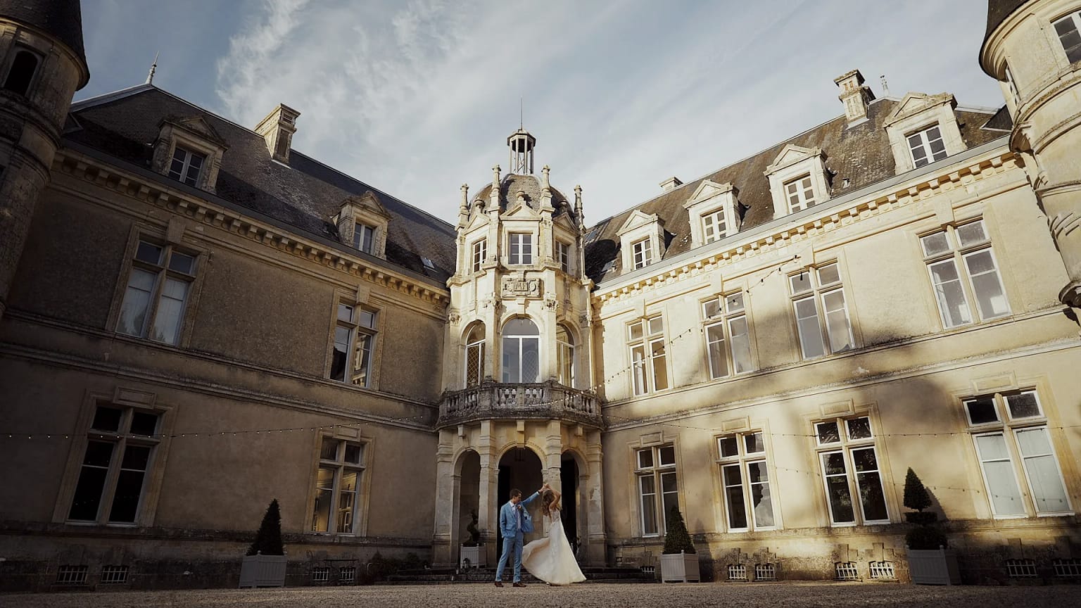 Couple dances at elegant historic building courtyard