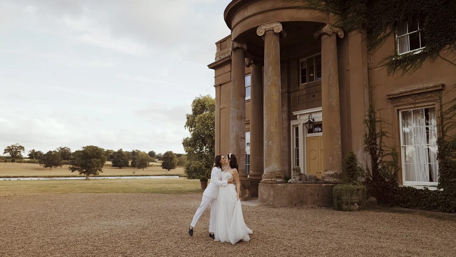 Couple embraces outside historic building.