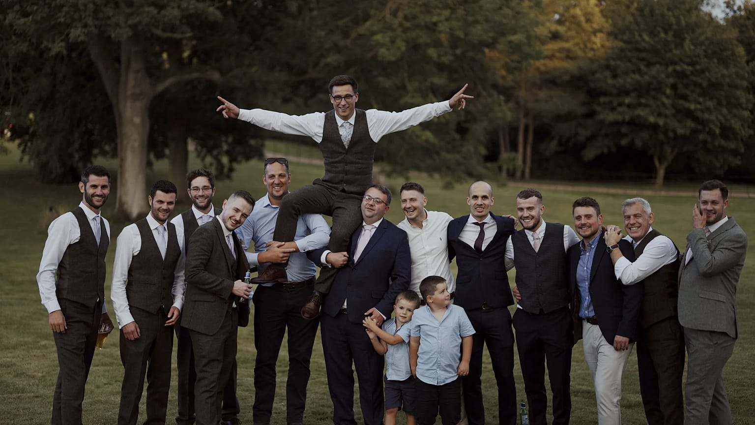 Group of men posing in suits outdoors.