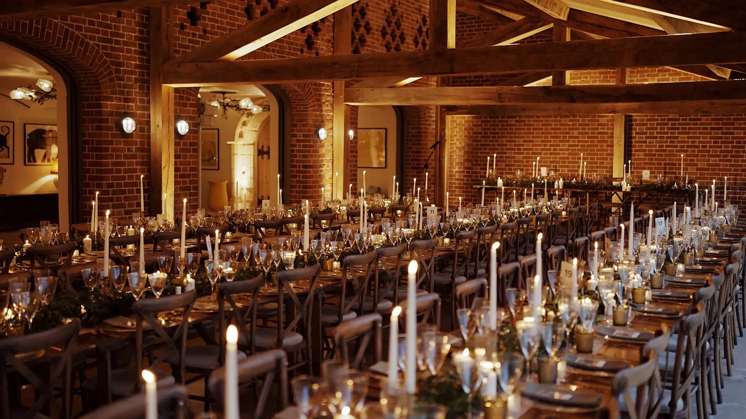 Elegant rustic wedding reception with candlelit tables.