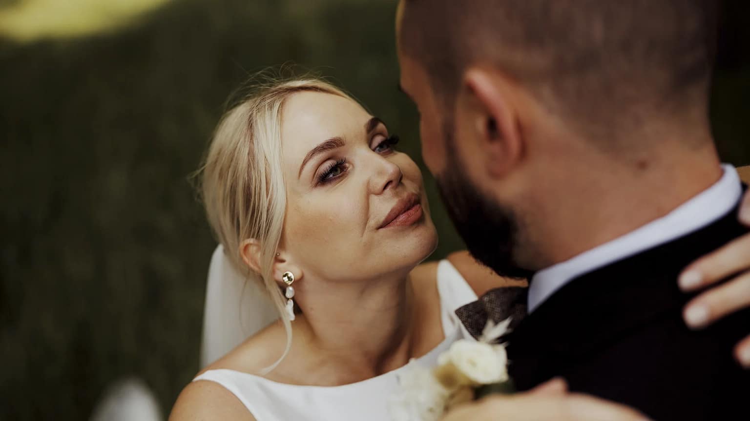 Close-up of bride and groom embracing lovingly.