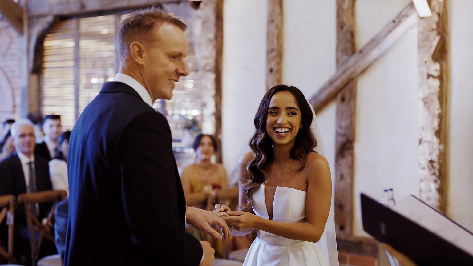 Bride and groom exchange rings at wedding ceremony.