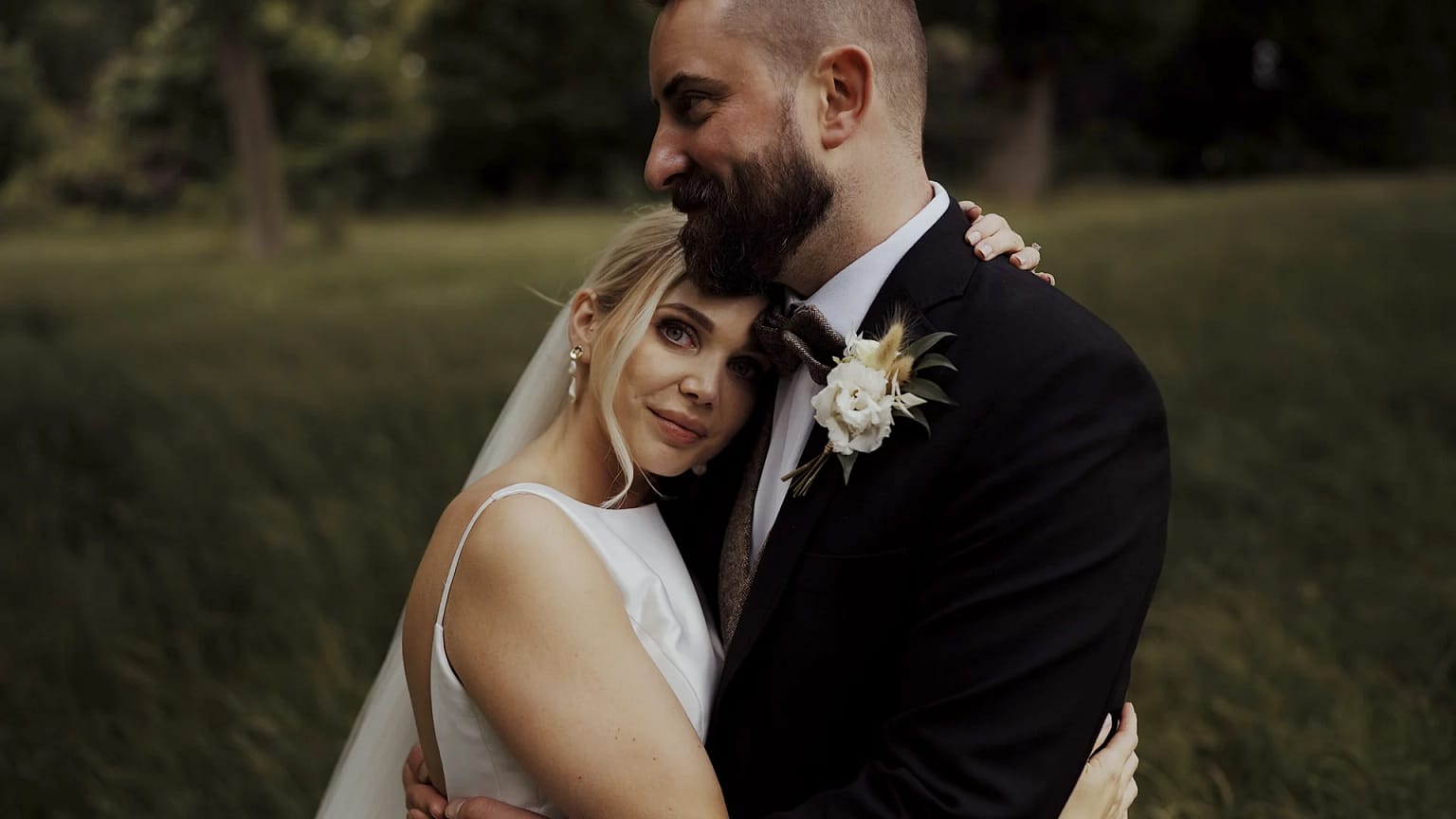 Couple embracing in a wedding scene outdoors.
