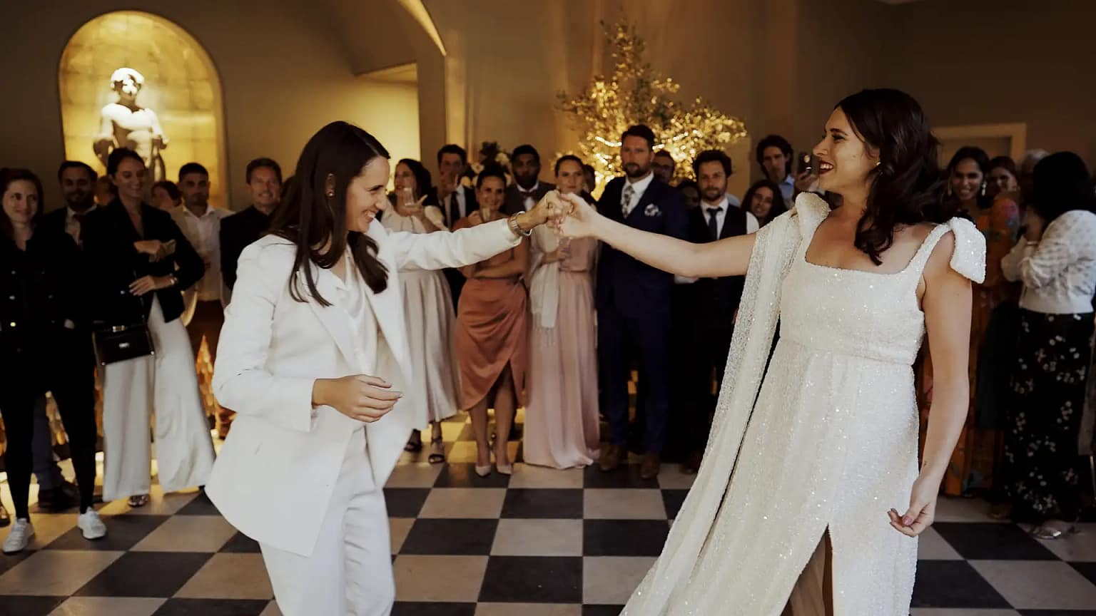 Couple dancing at wedding reception with guests watching.
