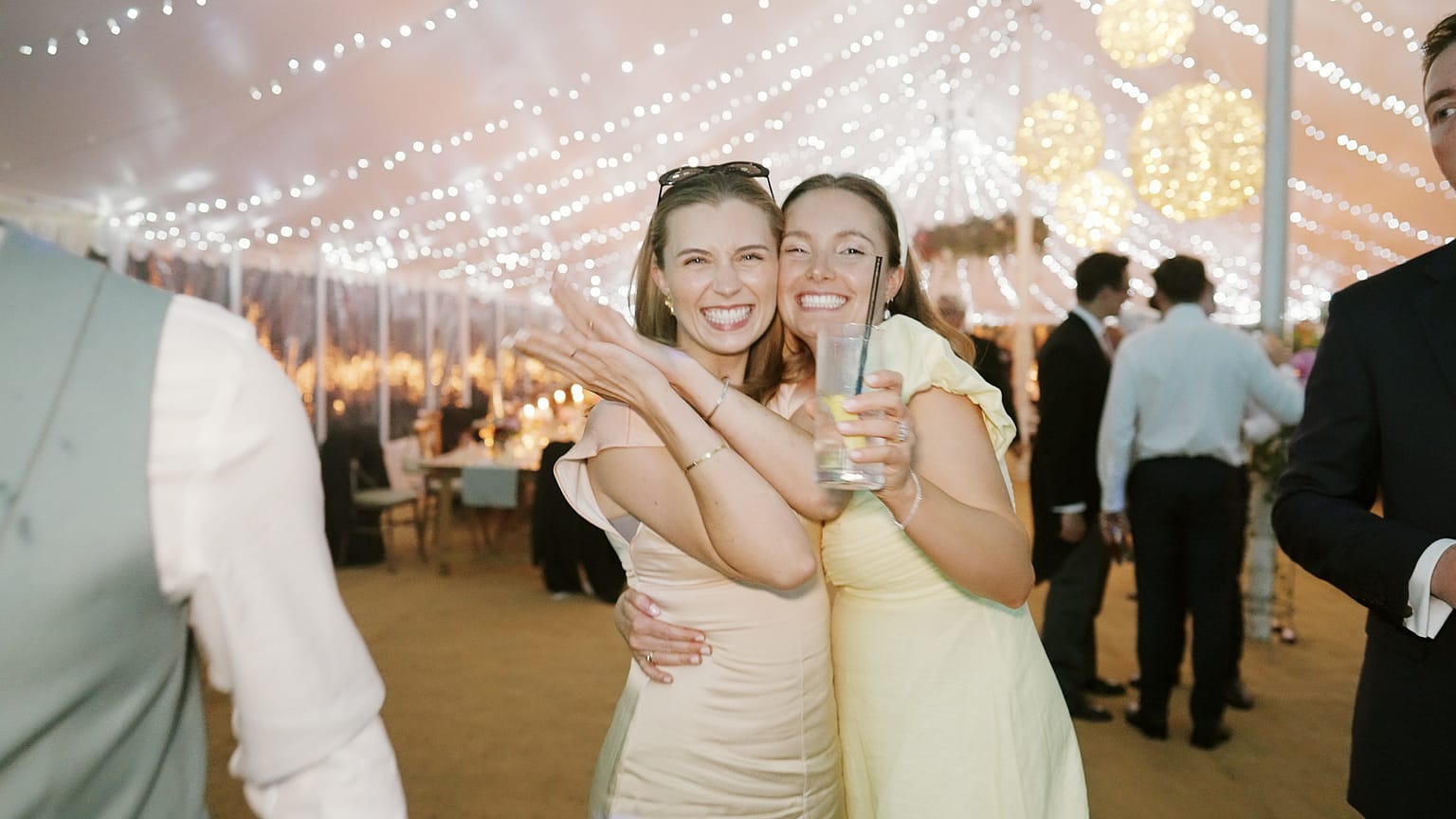 Two women smiling at a festive celebration.