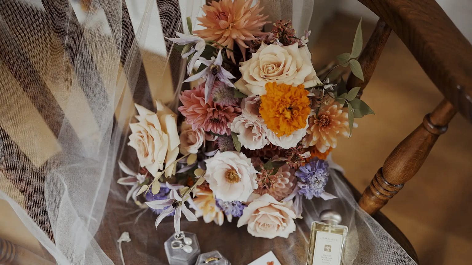 Colorful bouquet on wooden chair with veil
