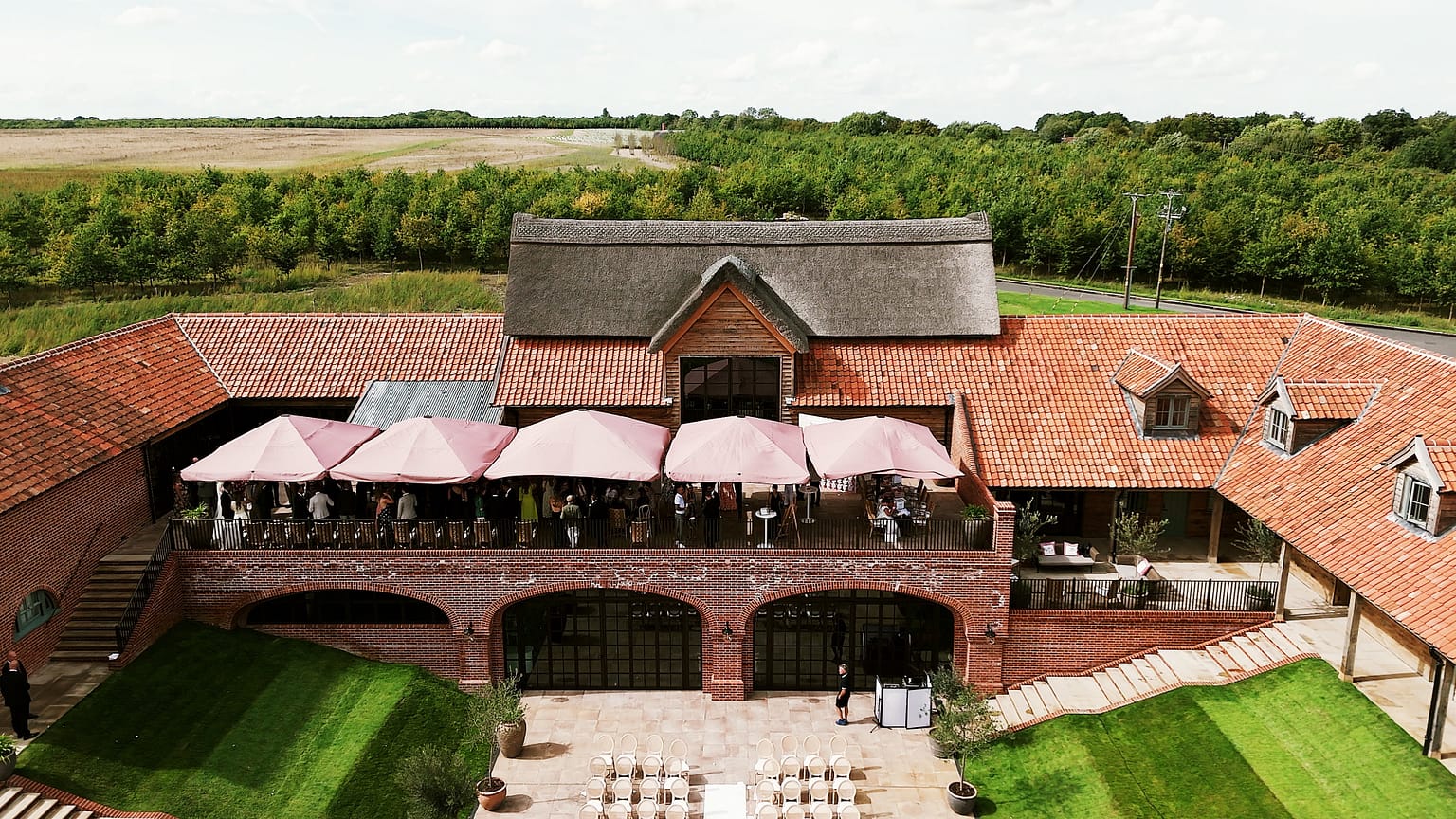 Rustic event venue with red roof and umbrellas.