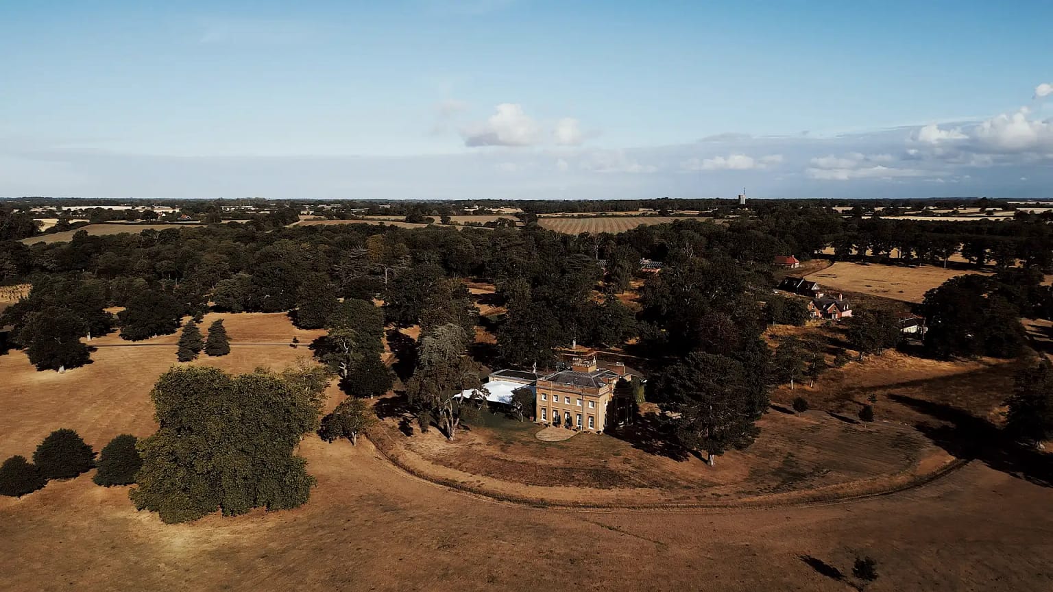 Aerial view of countryside estate with historic building.