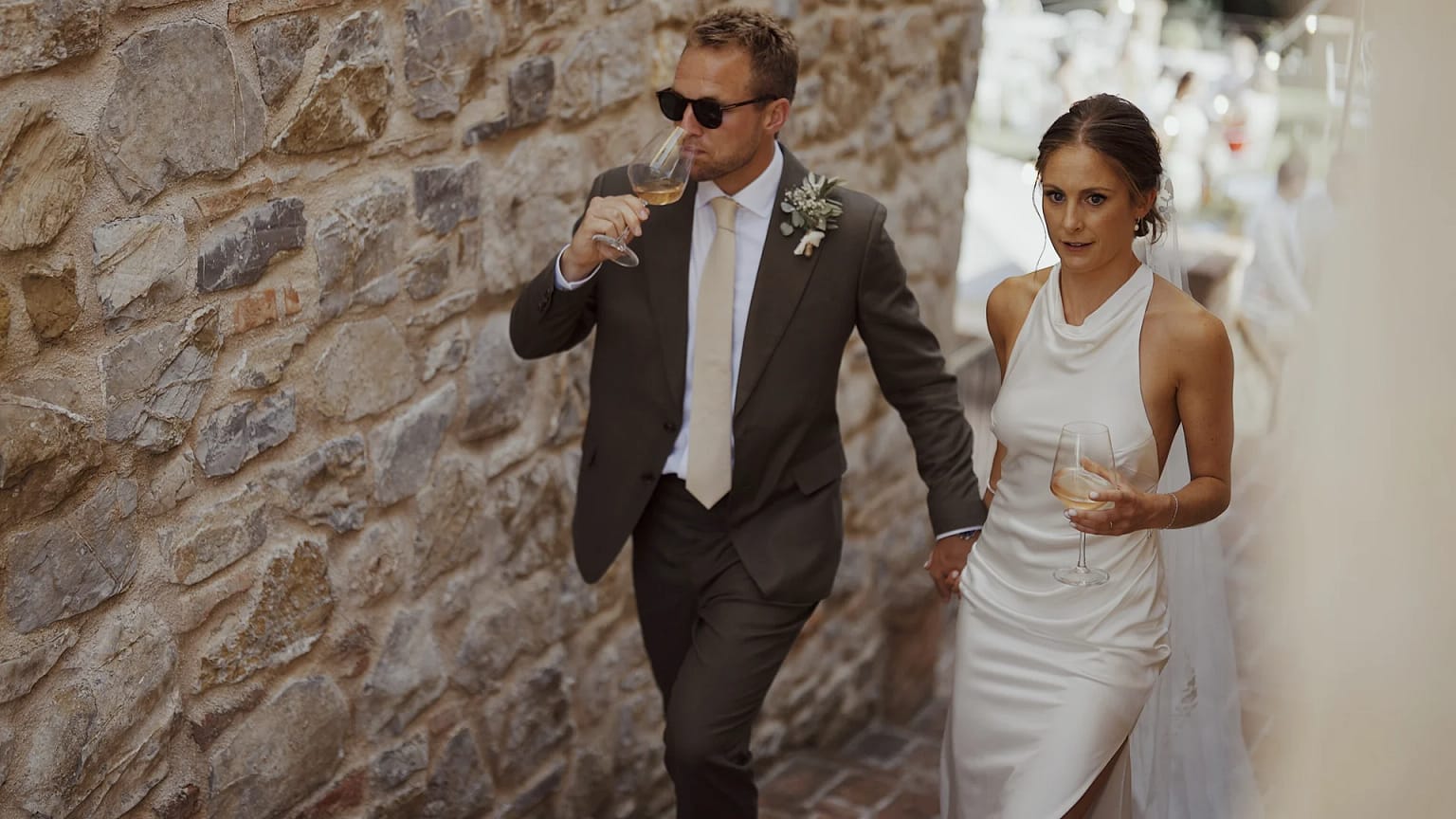 Couple walking, holding wine glasses