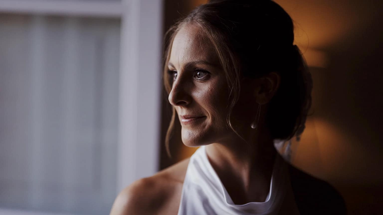 Woman in formal attire looking out window