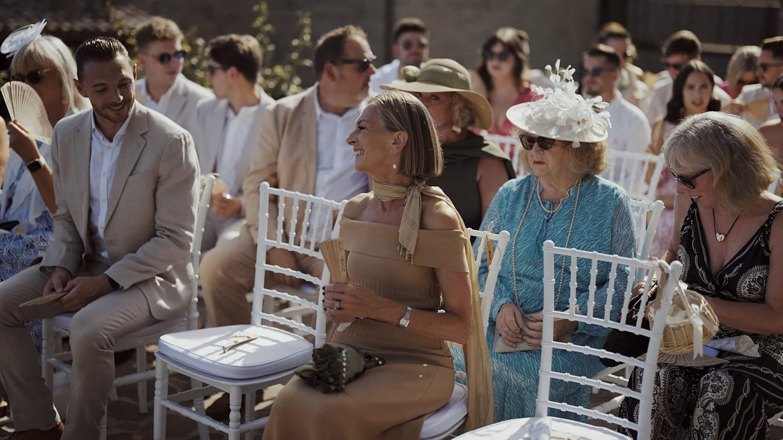 Guests seated outdoors at a formal event.