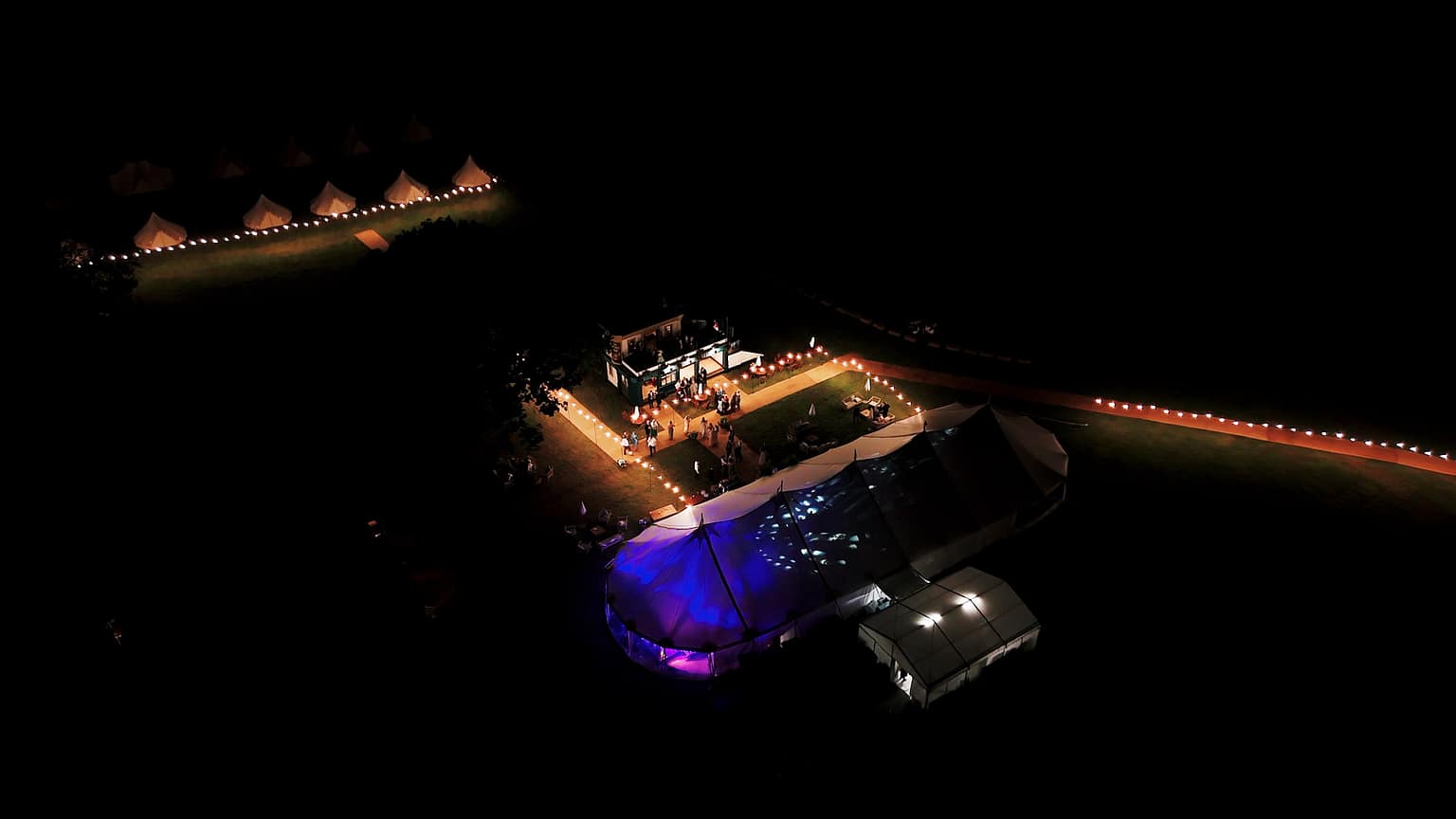 Night aerial view of illuminated tent event