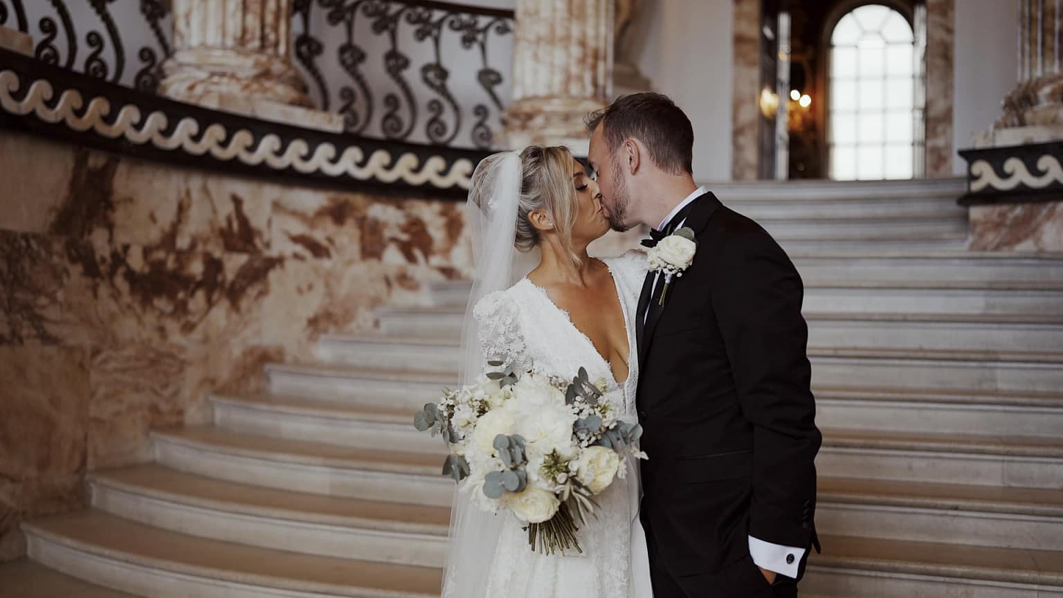 Bride and groom kissing on staircase