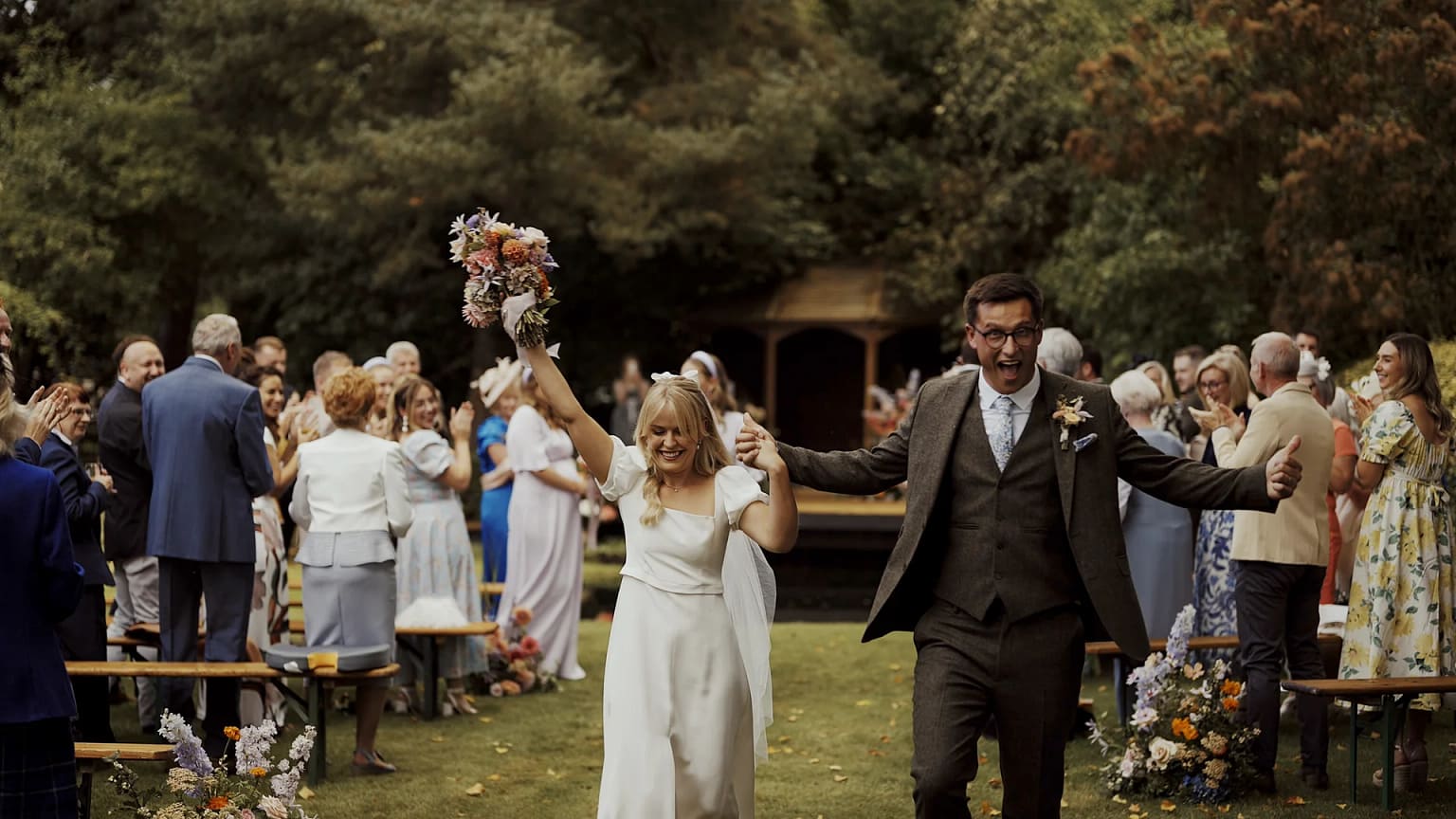 Bride and groom celebrate outdoor wedding ceremony.