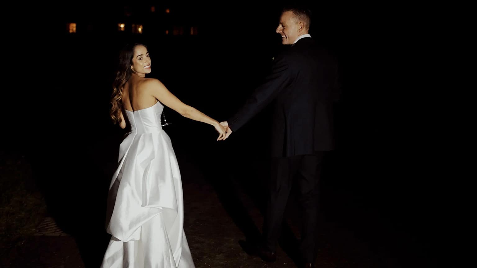 Bride and groom walking hand in hand.