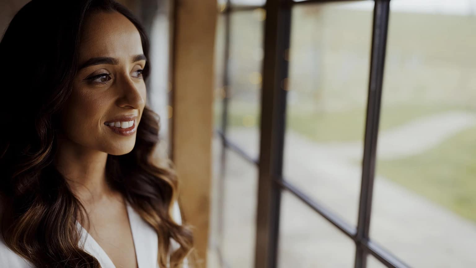 Woman smiling while looking out a window.
