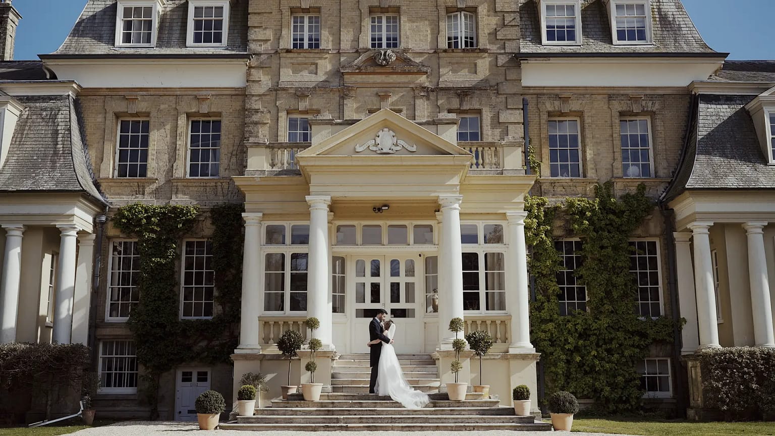 Wedding couple kissing on mansion steps