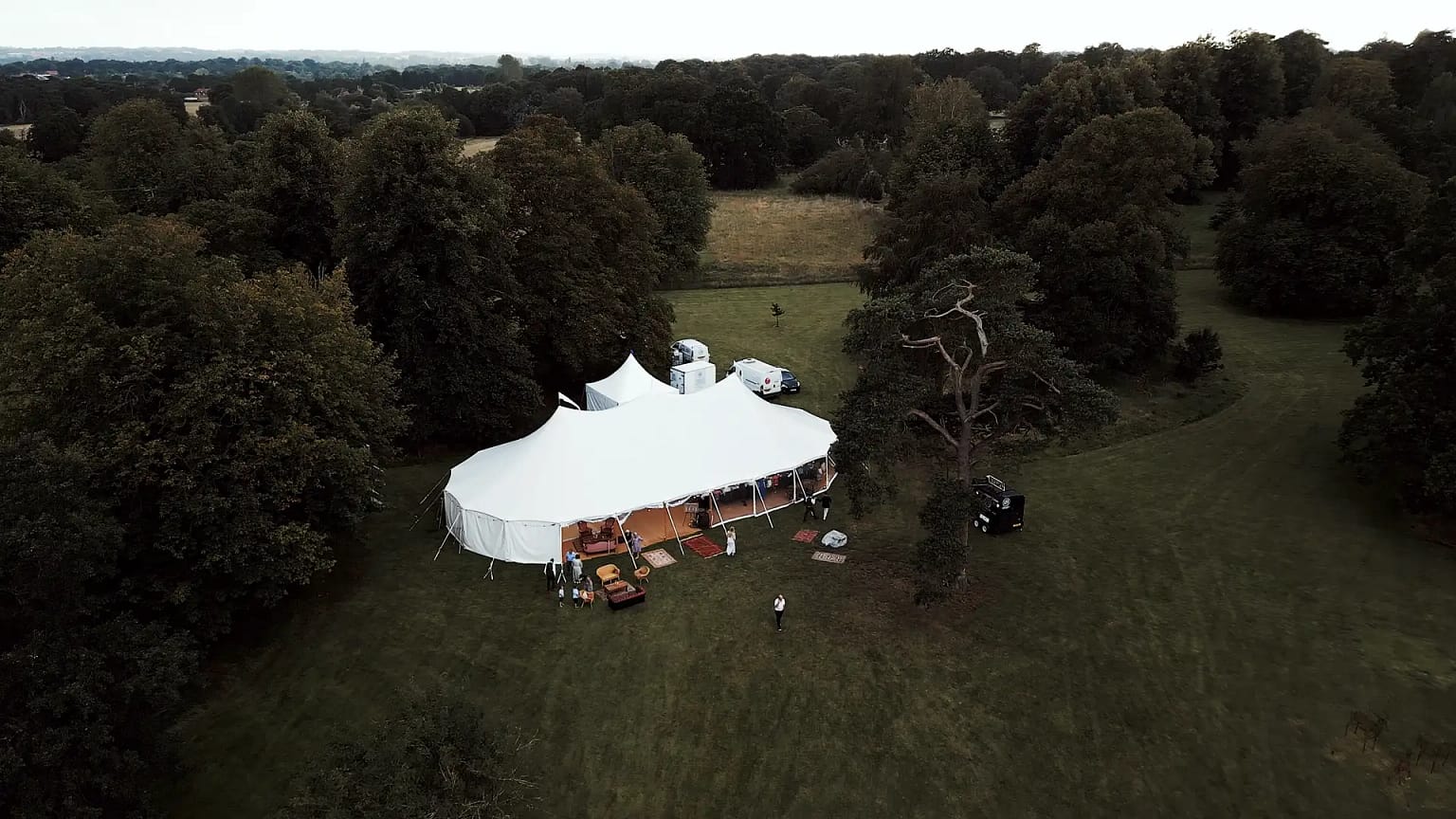 Large white tent in a forest clearing