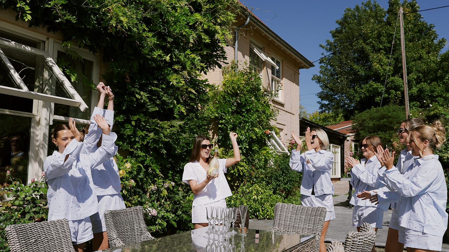 Women celebrating with champagne in sunny garden