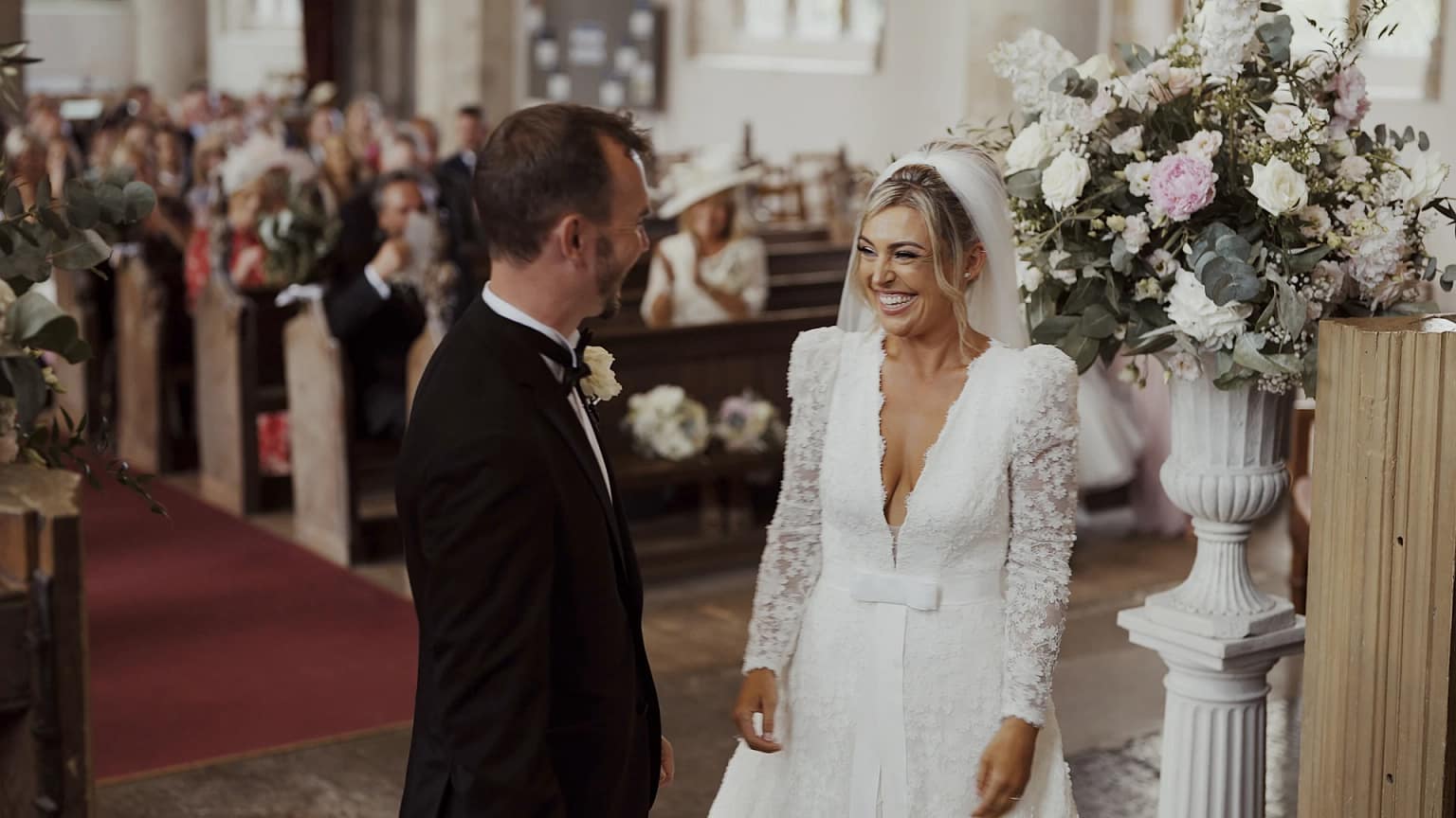 Bride and groom smiling at wedding ceremony.