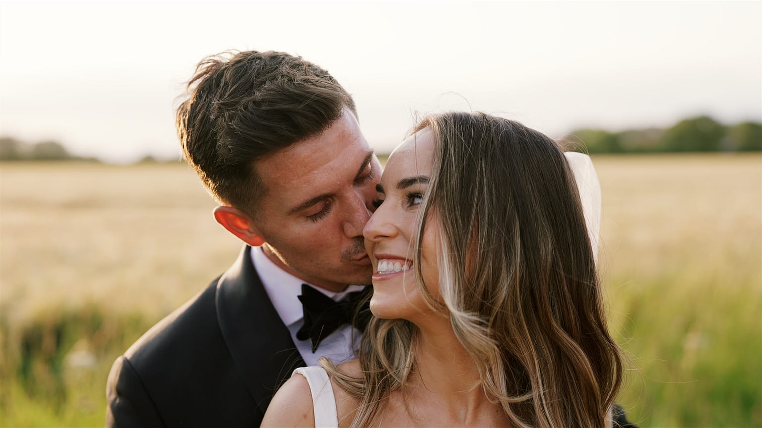 Happy couple embracing in sunny Norfolk field