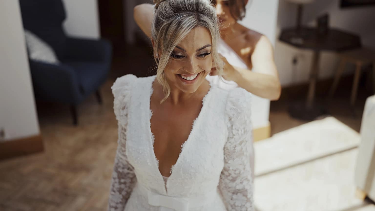 Bride smiling while getting ready in wedding dress