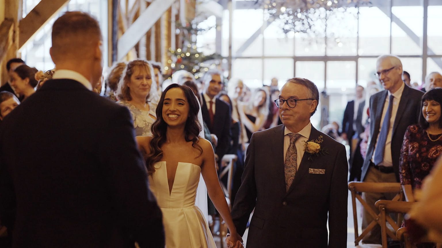 Bride walking down aisle with father at wedding.