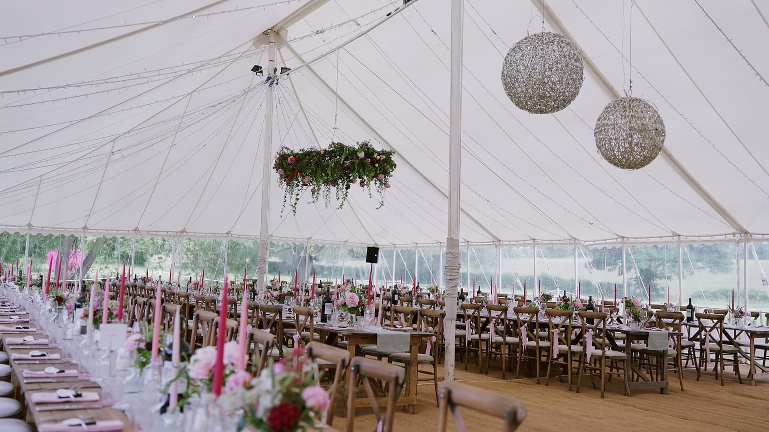 Elegant wedding marquee with floral arrangements and candles.