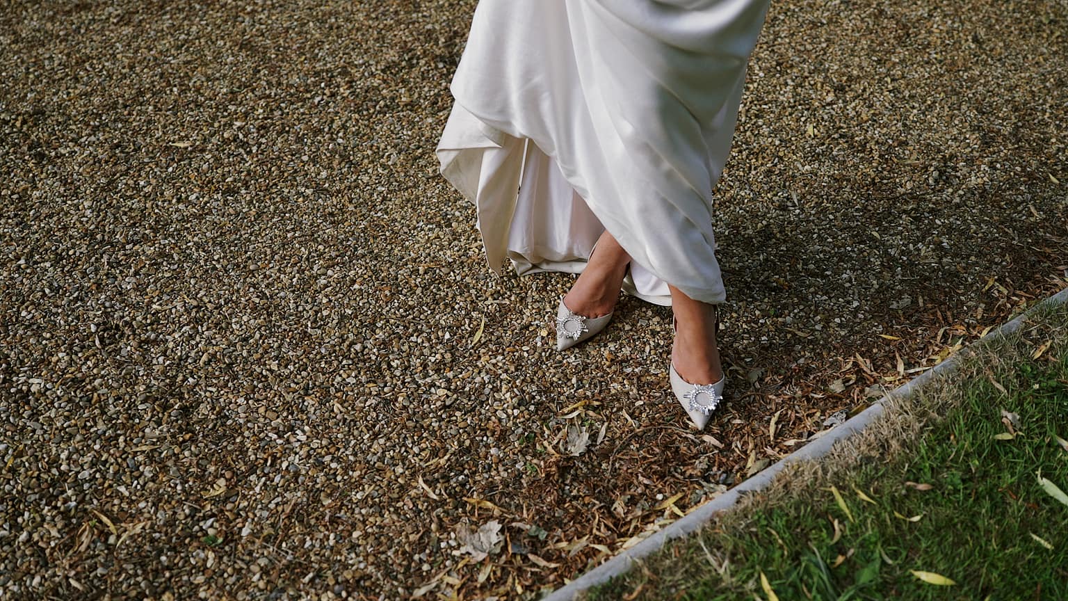 Woman in elegant dress standing on gravel path