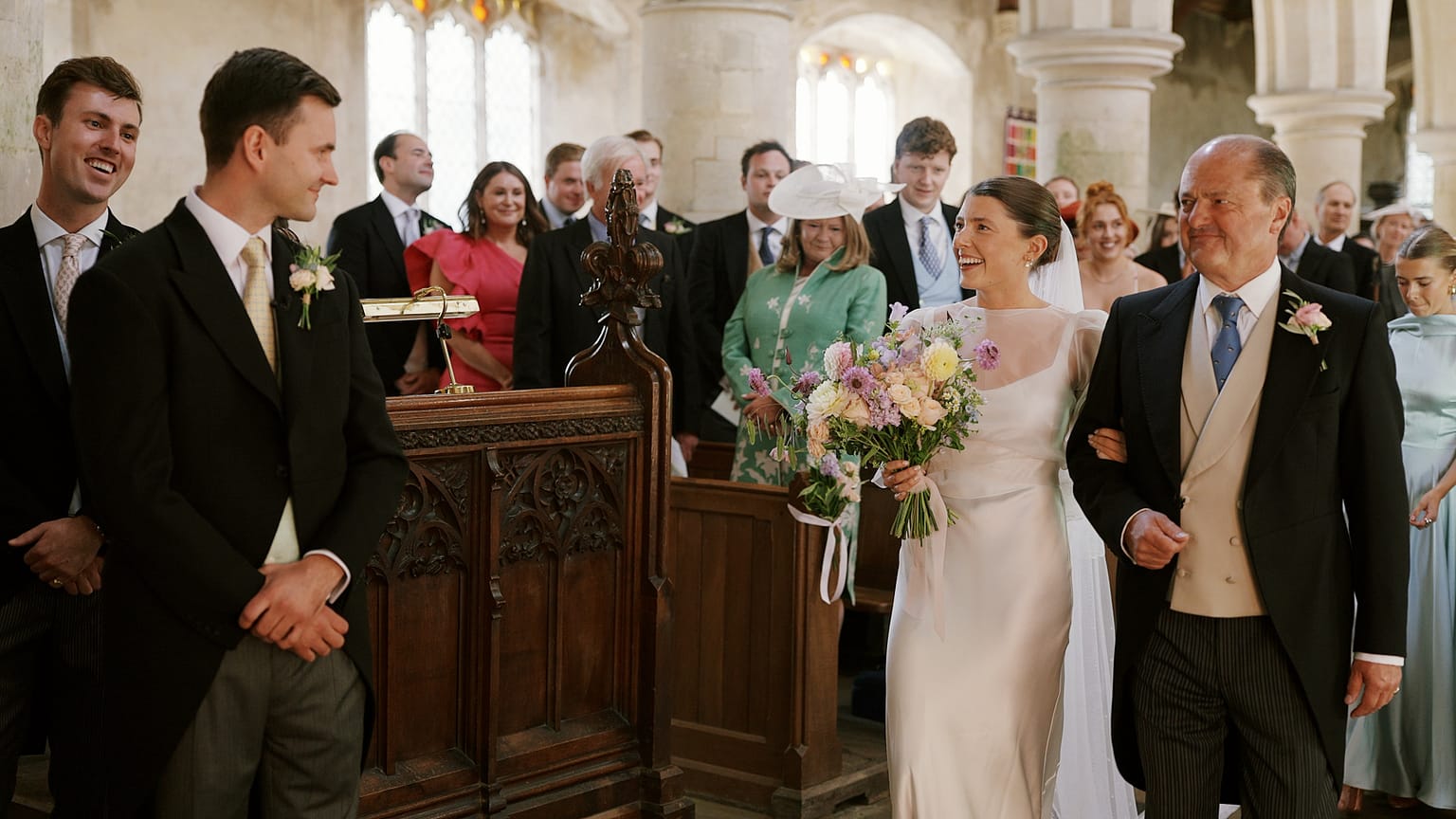 Bride walking down aisle with father in church