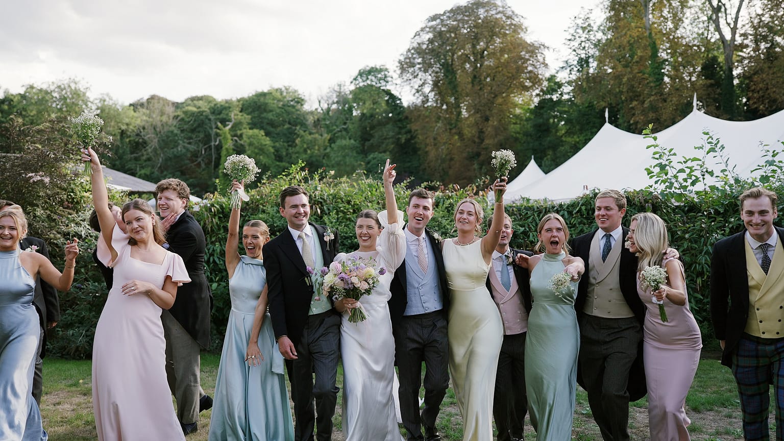 Wedding party celebrating outdoors with bride and groom