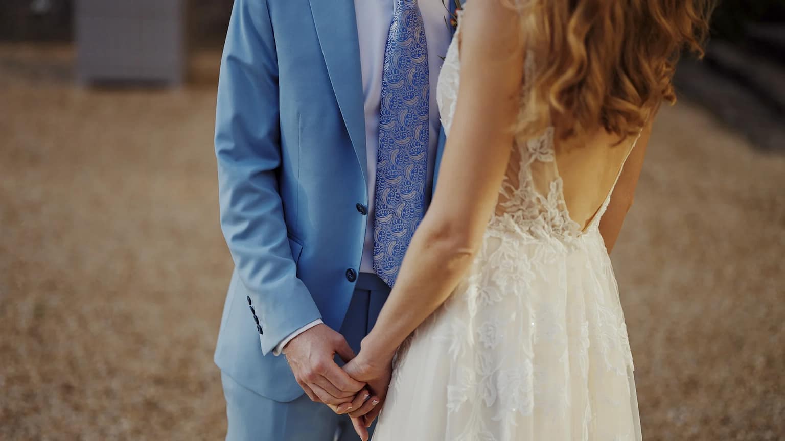 Bride and groom holding hands outdoors.
