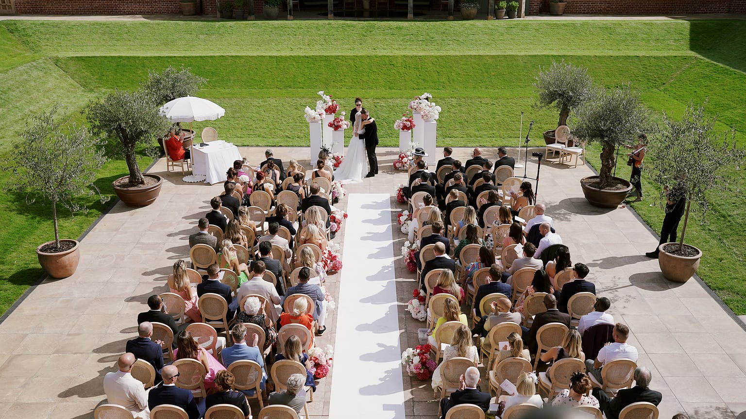 Outdoor wedding ceremony with guests and newlyweds.