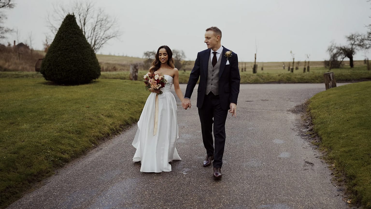 Bride and groom walking on country road