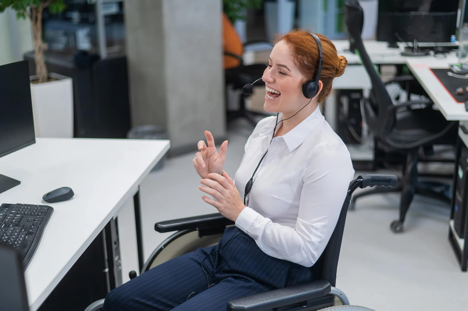Smiling woman in wheelchair working with headset