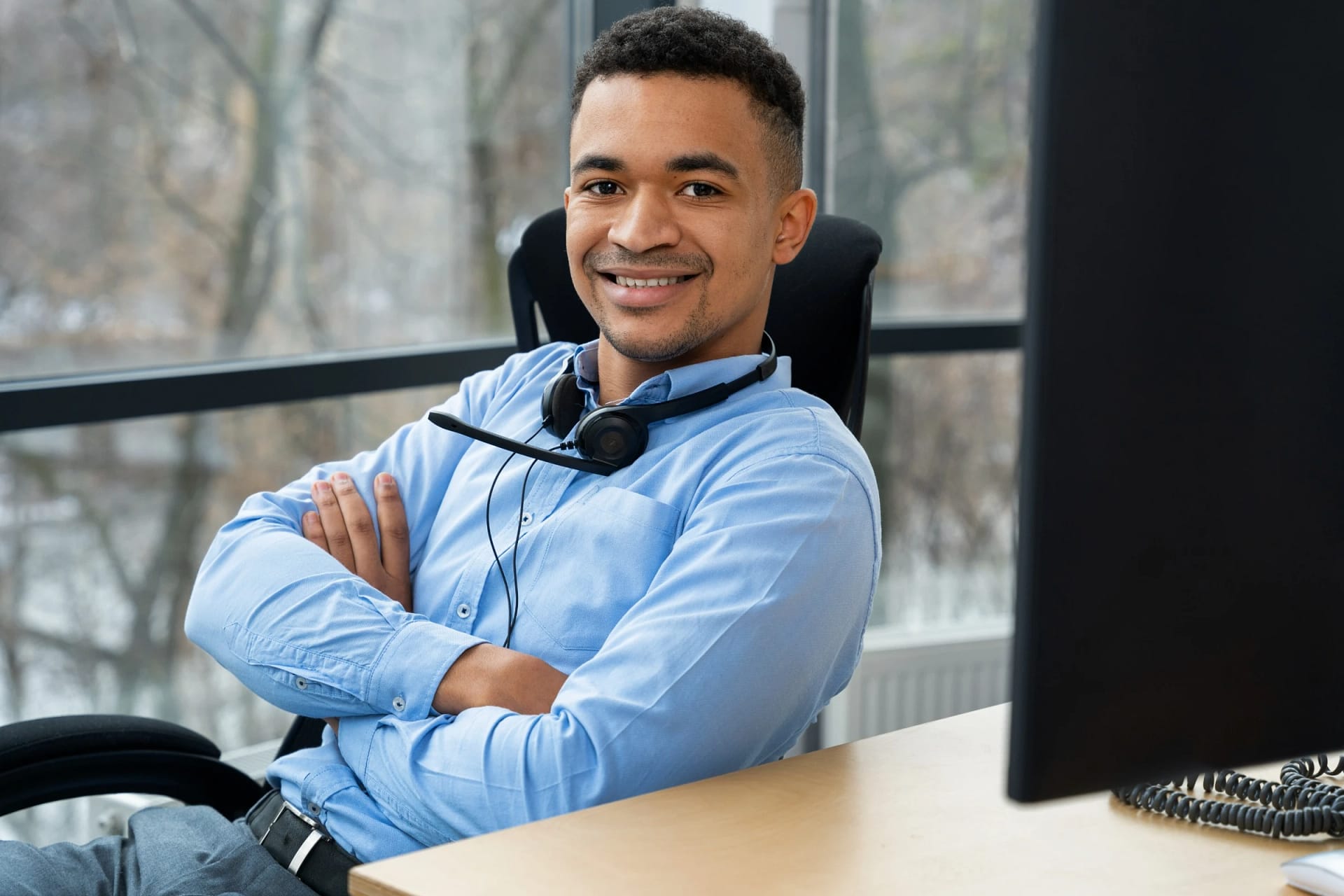 Smiling call center agent at office desk